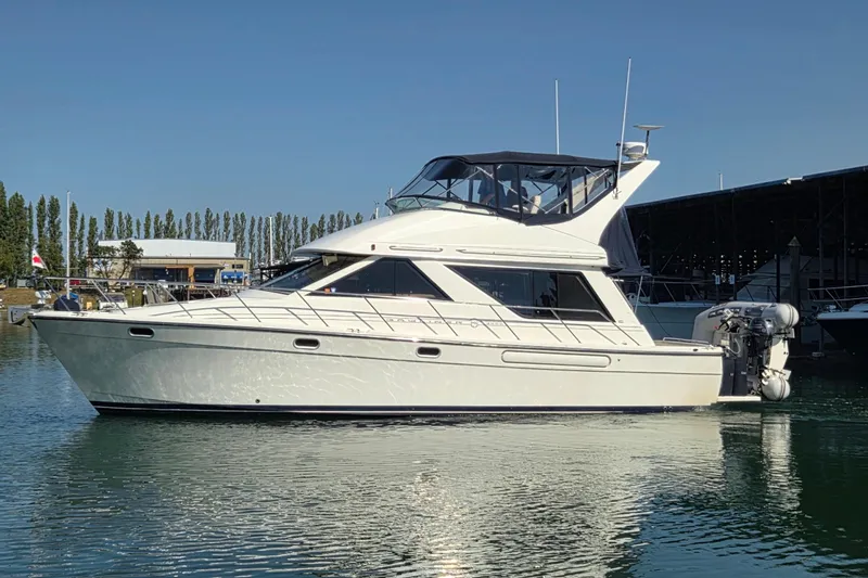  Yacht Photos Pics 1999 Bayliner 3988 Command Bridge Motoryacht on calm water, docked at marina.