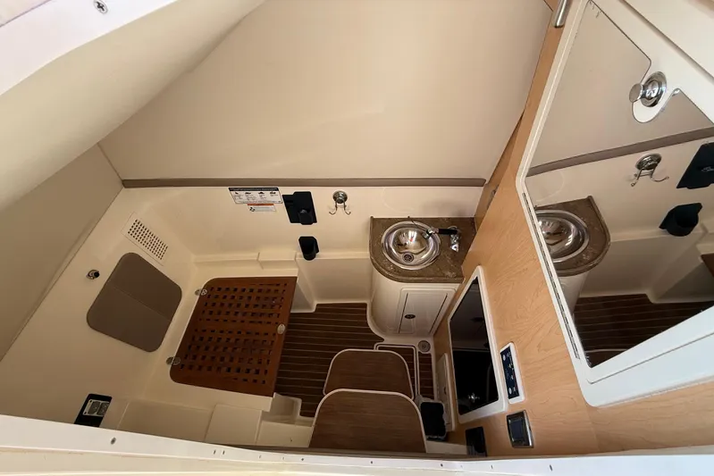  Yacht Photos Pics 2016 World Cat 320 DC boat interior with sink, wooden flooring, and storage.