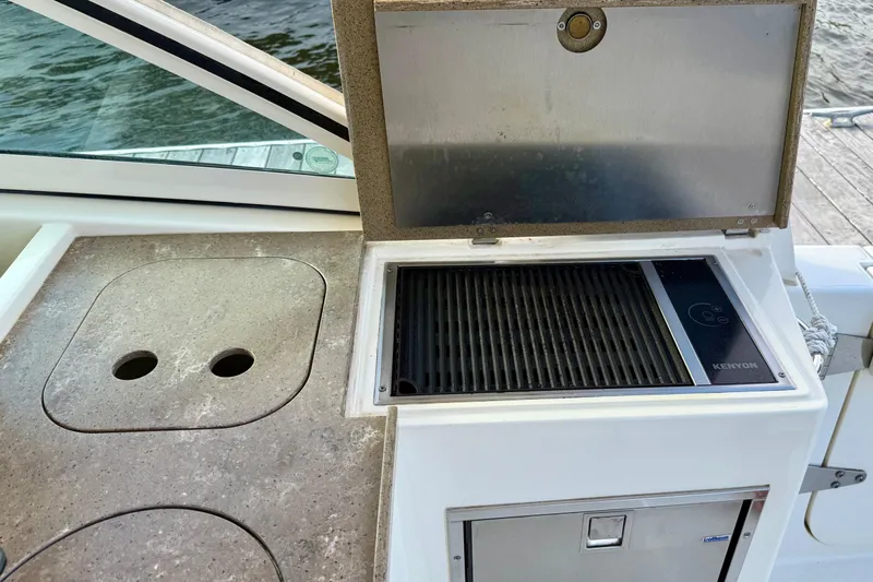  Yacht Photos Pics 2016 World Cat 320 DC boat with Kenyon grill and countertop near water.
