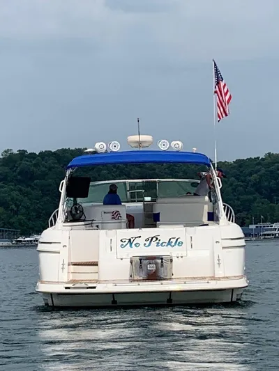  Yacht Photos Pics 2000 Cruisers Yachts 4270 Express boat on water, American flag, rear view.