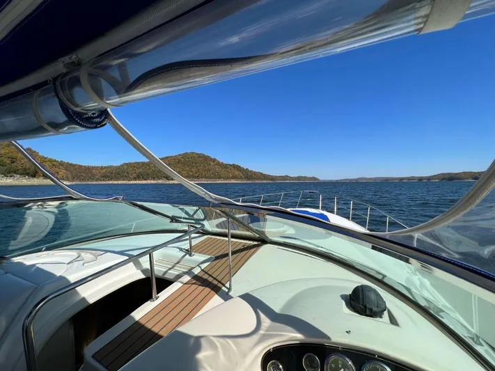  Yacht Photos Pics 2000 Cruisers Yachts 4270 Express on serene lake with clear blue sky.