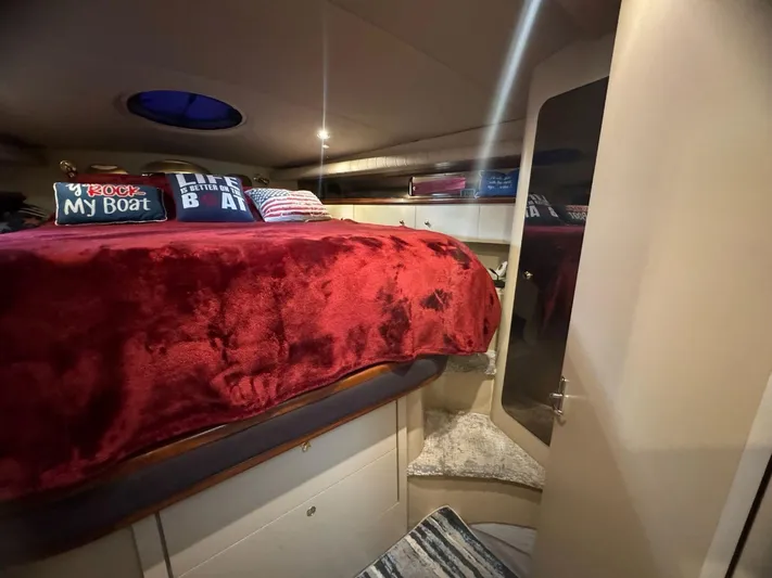  Yacht Photos Pics Cozy cabin interior of 2000 Cruisers Yachts 4270 Express with red bedding and nautical decor.