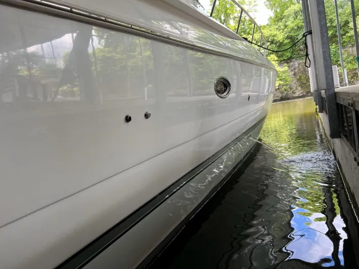  Yacht Photos Pics 2000 Cruisers Yachts 4270 Express docked, side view reflecting on calm water.