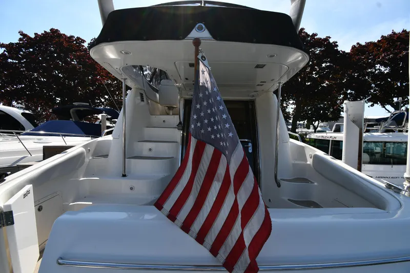  Yacht Photos Pics 2003 Regal Commodore 3880 yacht with American flag, docked under sunny skies.