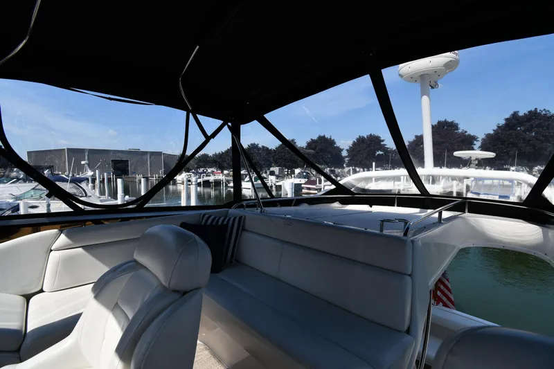  Yacht Photos Pics Interior view of 2003 Regal Commodore 3880 yacht at marina, featuring white seating and canopy.