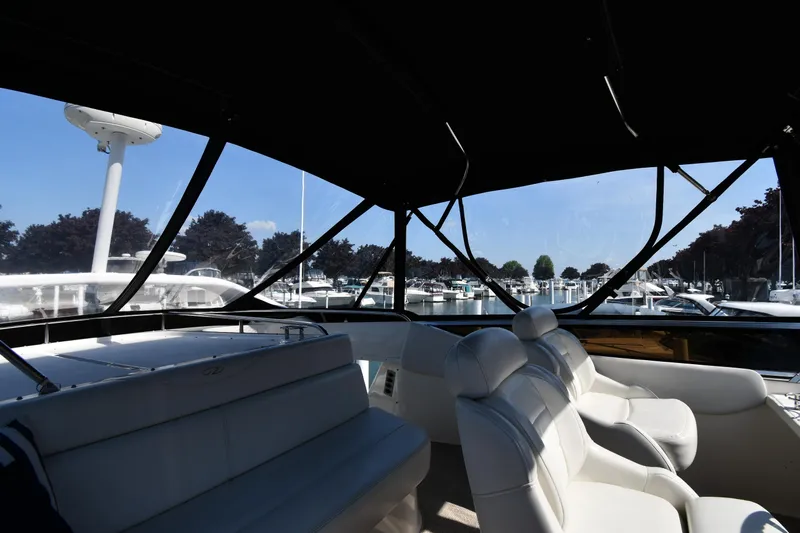  Yacht Photos Pics Interior view of 2003 Regal Commodore 3880 yacht with white seating and marina backdrop.