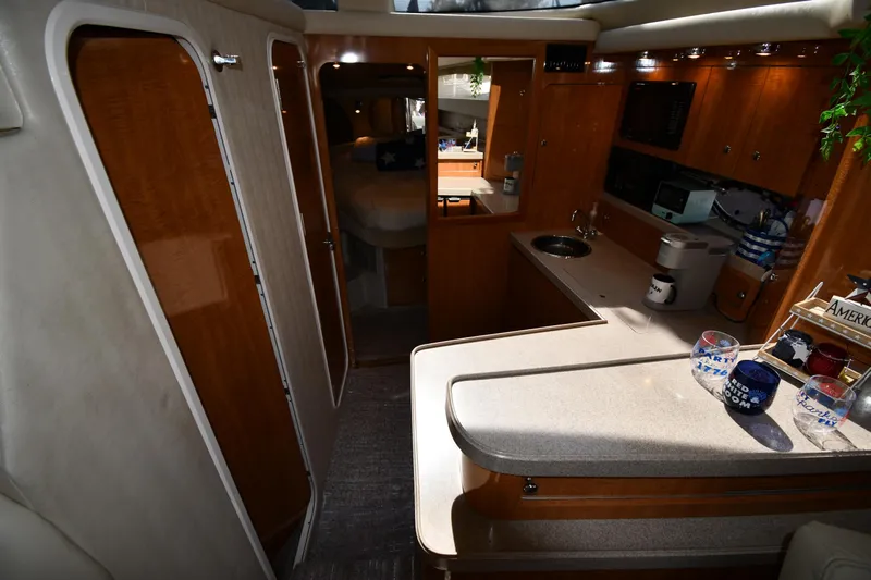  Yacht Photos Pics Interior of 2003 Regal Commodore 3880 yacht with kitchenette and cozy cabin space.