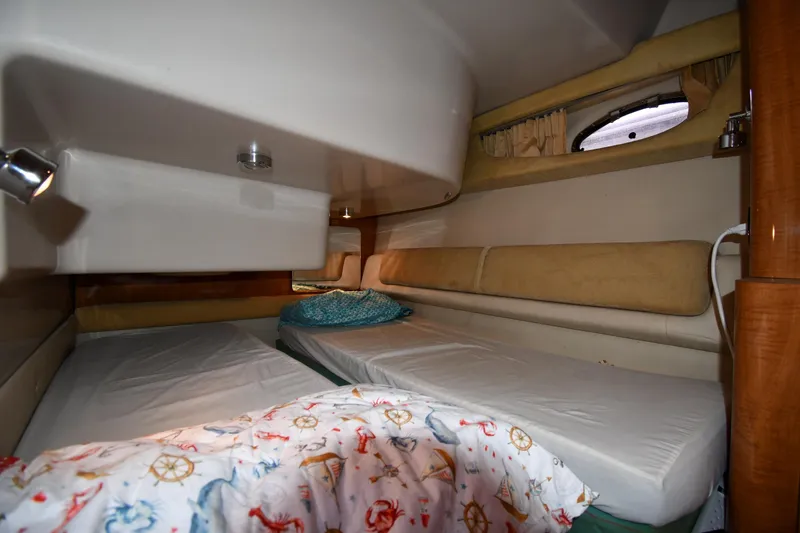  Yacht Photos Pics Interior cabin of 2003 Regal Commodore 3880 yacht with twin beds and nautical-themed bedding.