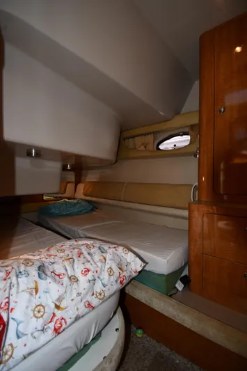  Yacht Photos Pics Interior cabin of 2003 Regal Commodore 3880 yacht with cozy bedding and wooden cabinetry.