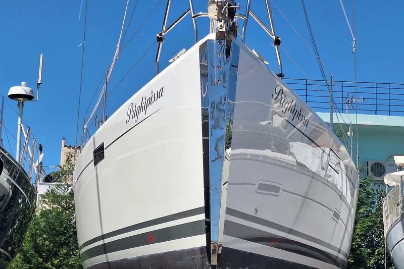  Yacht Photos Pics 2014 Hanse 385 sailboat on land, reflecting sunlight, with clear blue sky background.