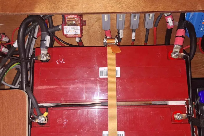  Yacht Photos Pics Battery compartment of a 2014 Hanse 385 yacht with secured red battery and cables.