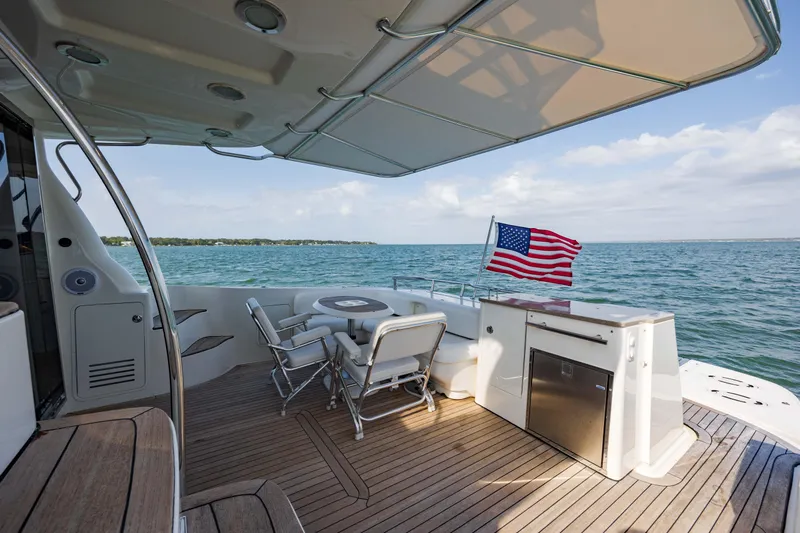 Beautiful Blue Yacht Photos Pics 2008 Sea Ray 52 Sedan Bridge yacht deck with seating, American flag, and ocean view.