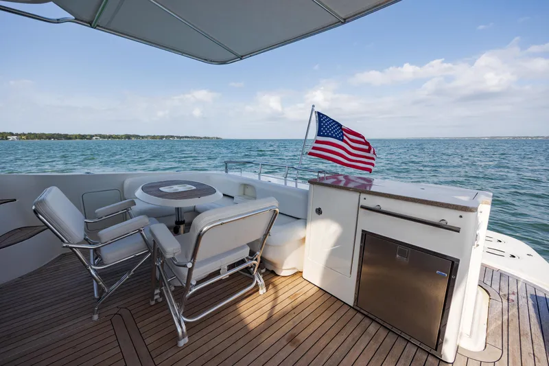 Beautiful Blue Yacht Photos Pics 2008 Sea Ray 52 Sedan Bridge yacht deck with seating, table, and American flag.