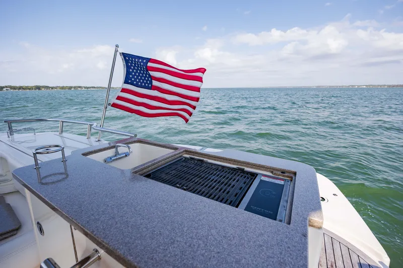 Beautiful Blue Yacht Photos Pics 2008 Sea Ray 52 Sedan Bridge yacht with American flag and outdoor grill on deck.