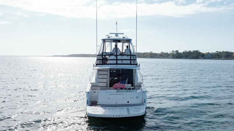 Beautiful Blue Yacht Photos Pics 2008 Sea Ray 52 Sedan Bridge yacht on open water, rear view with American flag.