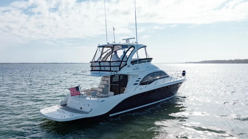 Beautiful Blue Yacht Photos Pics 2008 Sea Ray 52 Sedan Bridge yacht cruising on open water under a clear sky.