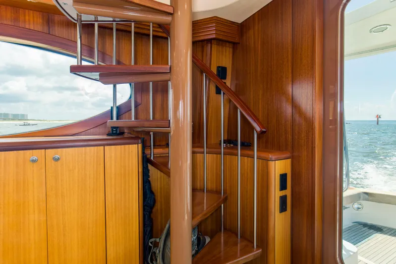 Refuge Yacht Photos Pics Interior of 2007 Hatteras 68 Enclosed Bridge yacht with wooden spiral staircase.