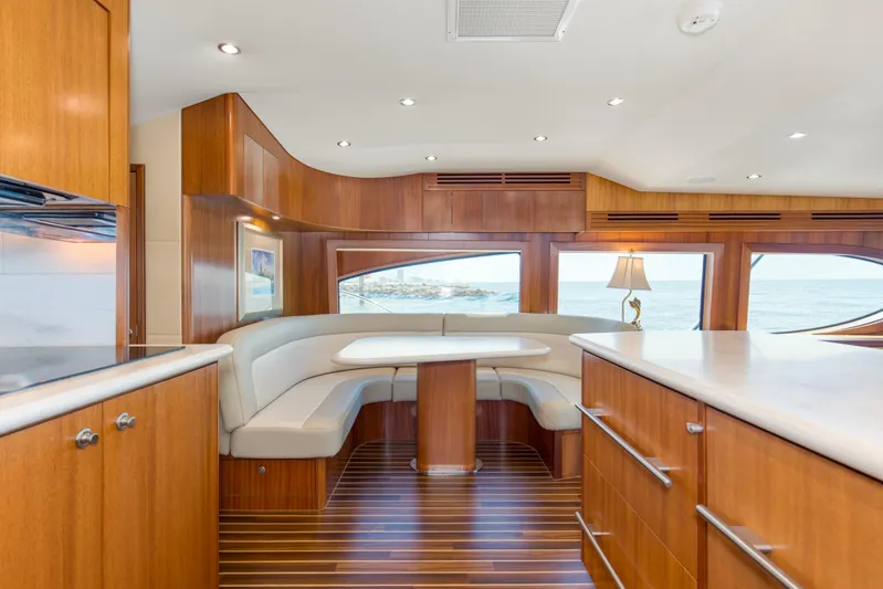 Refuge Yacht Photos Pics Luxurious interior of 2007 Hatteras 68 Enclosed Bridge yacht with elegant wood finishes and ocean view.