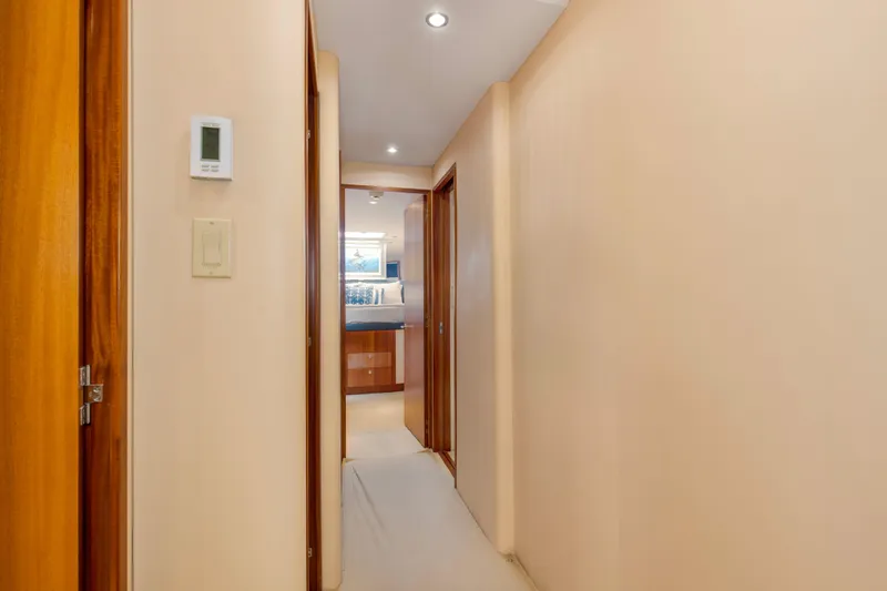 Refuge Yacht Photos Pics Hallway inside 2007 Hatteras 68 Enclosed Bridge yacht, featuring wooden doors and modern lighting.