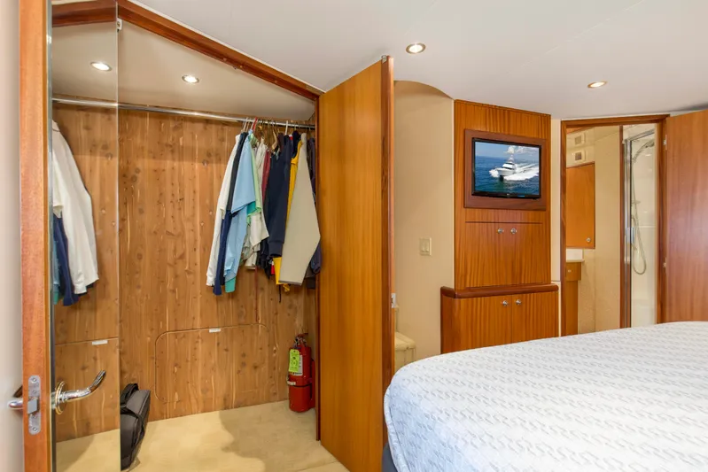 Refuge Yacht Photos Pics Luxurious 2007 Hatteras 68 Enclosed Bridge yacht bedroom with closet and TV.