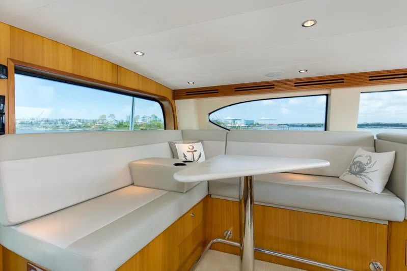 Refuge Yacht Photos Pics Luxurious interior of 2007 Hatteras 68 Enclosed Bridge yacht with elegant seating and scenic views.