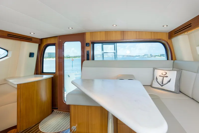 Refuge Yacht Photos Pics Luxurious interior of 2007 Hatteras 68 Enclosed Bridge yacht with elegant seating and nautical decor.