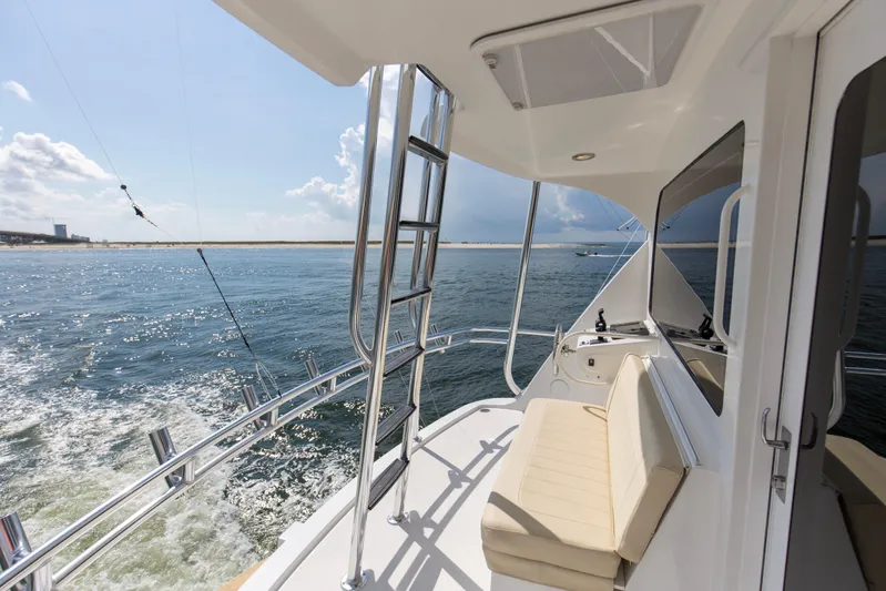 Refuge Yacht Photos Pics 2007 Hatteras 68 Enclosed Bridge yacht cruising on open water, featuring a sleek deck design.