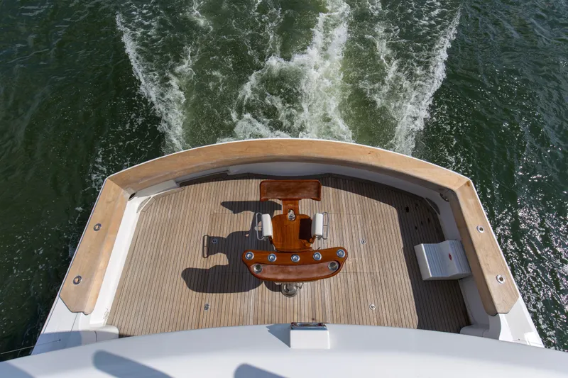 Refuge Yacht Photos Pics 2007 Hatteras 68 Enclosed Bridge yacht deck with fishing chair, cruising on water.