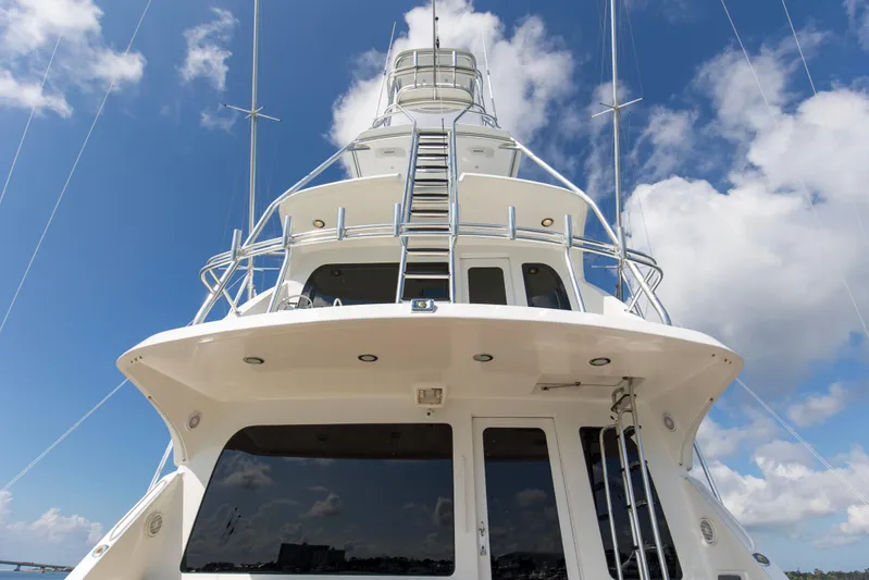 Refuge Yacht Photos Pics 2007 Hatteras 68 Enclosed Bridge yacht against a bright blue sky.