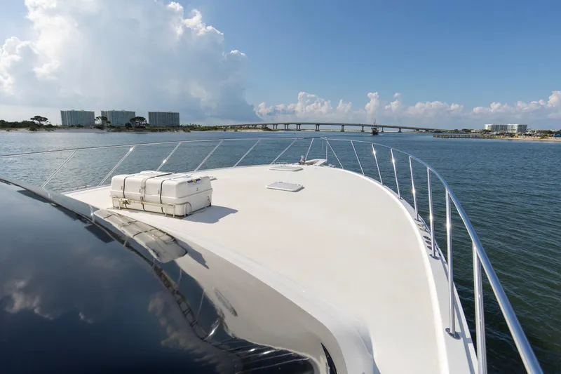 Refuge Yacht Photos Pics 2007 Hatteras 68 Enclosed Bridge yacht cruising near a coastal bridge under a clear sky.