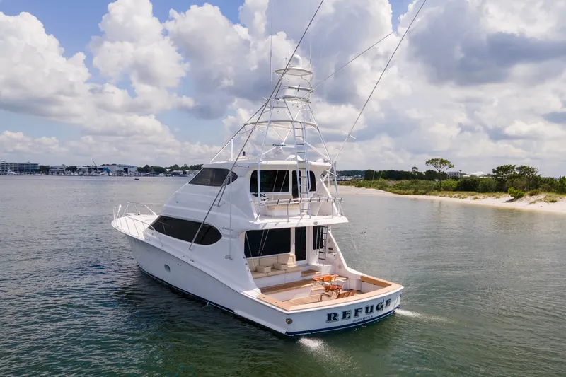 Refuge Yacht Photos Pics 2007 Hatteras 68 Enclosed Bridge yacht cruising near sandy shoreline under cloudy sky.