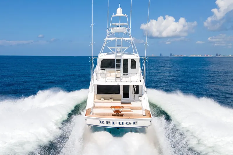 Refuge Yacht Photos Pics 2007 Hatteras 68 Enclosed Bridge yacht cruising on open sea with city skyline.