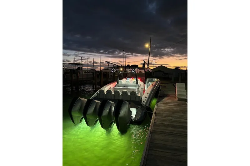  Yacht Photos Pics 2022 Midnight Express 43 Open boat docked at sunset with illuminated water.