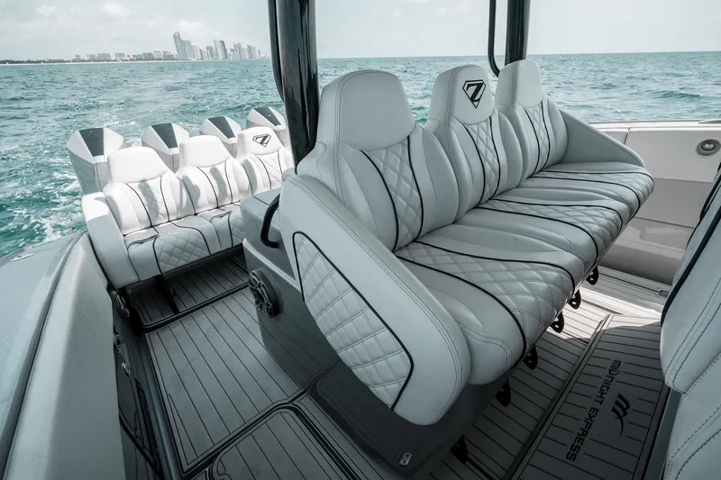  Yacht Photos Pics Luxurious seating on 2022 Midnight Express 43 Open boat, with ocean and city skyline backdrop.