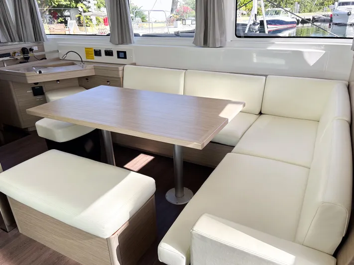 Southern Isle Yacht Photos Pics 2024 Lagoon 46 yacht interior with beige sofa and table.
