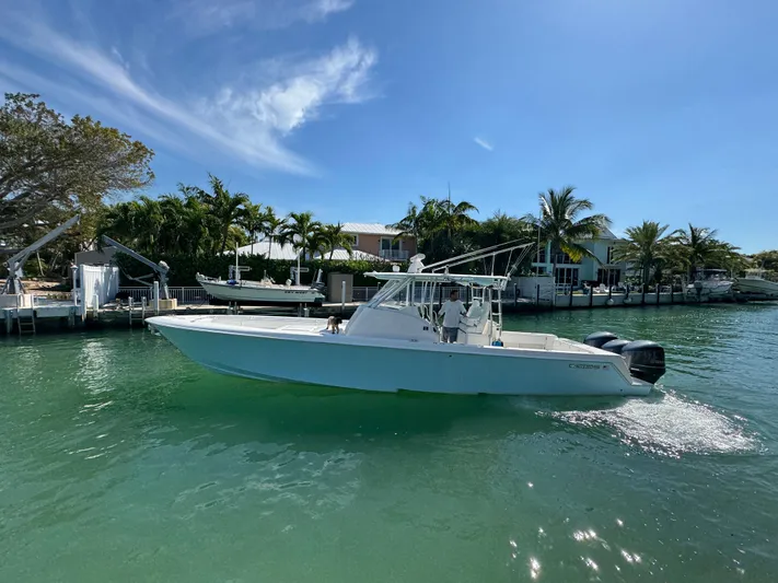  Yacht Photos Pics 2021 Contender 39 Fisharound boat cruising on a sunny day in a tropical canal.