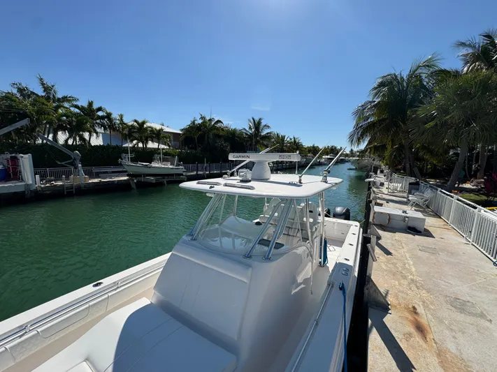  Yacht Photos Pics 2021 Contender 39 Fisharound boat docked by a tropical canal.