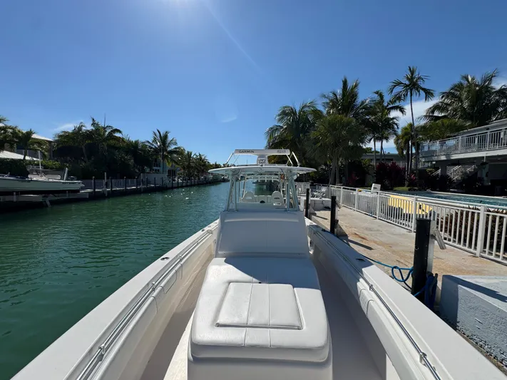  Yacht Photos Pics 2021 Contender 39 Fisharound boat docked by a tropical canal.