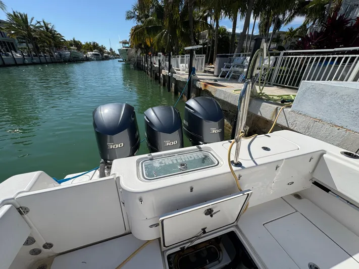  Yacht Photos Pics 2021 Contender 39 Fisharound with triple 300 horsepower engines docked by a canal.