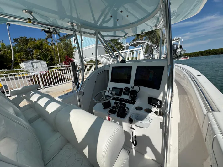  Yacht Photos Pics 2021 Contender 39 Fisharound boat cockpit with modern controls and seating, docked by the water.