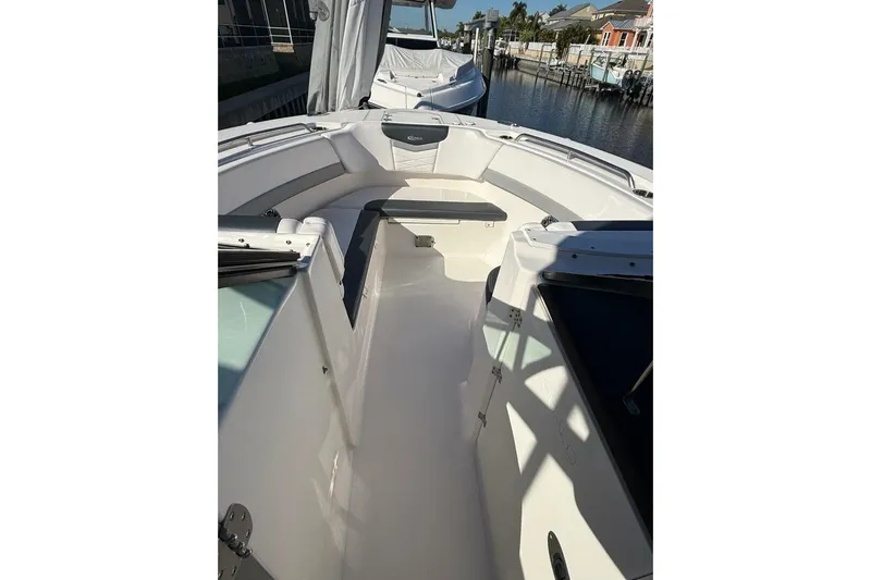 E Komo Mai Yacht Photos Pics 2021 Robalo R317 Dual Console boat interior with seating, docked near waterfront homes.