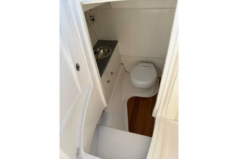 E Komo Mai Yacht Photos Pics 2021 Robalo R317 Dual Console boat interior with toilet and sink.