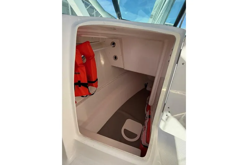 E Komo Mai Yacht Photos Pics Storage compartment in 2021 Robalo R317 Dual Console boat with life jackets.