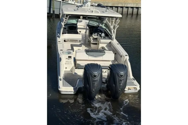 E Komo Mai Yacht Photos Pics 2021 Robalo R317 Dual Console boat with twin engines, docked in calm water.