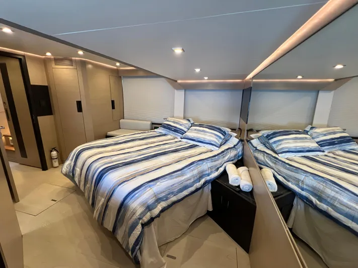  Yacht Photos Pics Luxurious bedroom interior of 2022 OKEAN Flybridge 50 yacht with striped bedding.