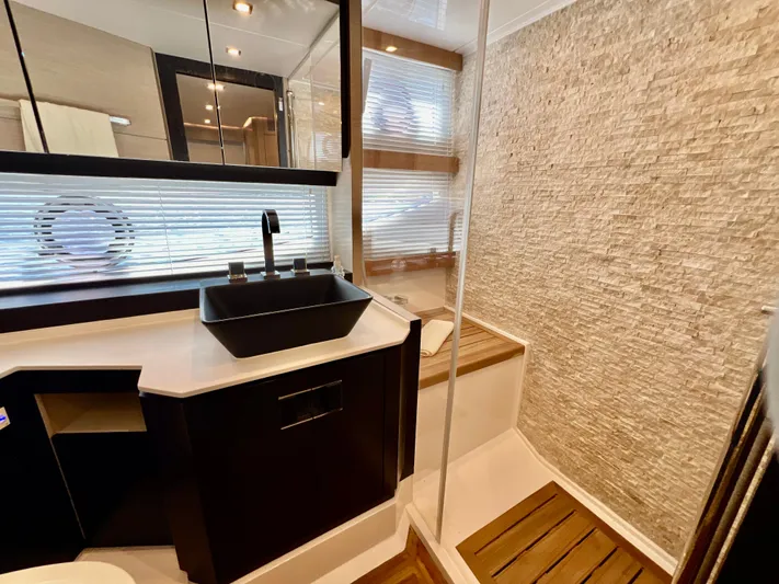  Yacht Photos Pics Modern bathroom on 2022 OKEAN Flybridge 50 yacht with sleek black sink and textured wall.