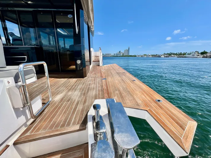  Yacht Photos Pics OKEAN Flybridge 50 2022 yacht with wooden deck, docked by the water on a sunny day.