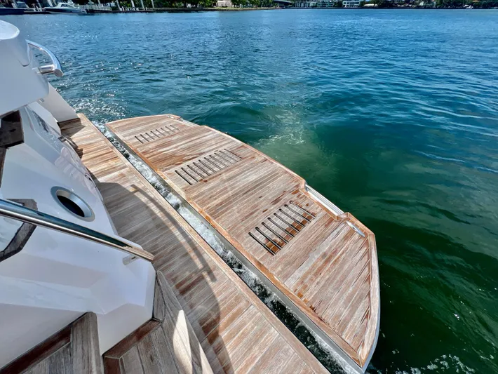  Yacht Photos Pics 2022 OKEAN Flybridge 50 yacht with extended wooden swim platform on calm water.