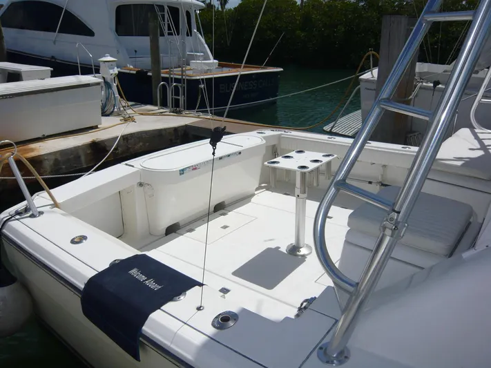 Bobalu Yacht Photos Pics 2004 Rampage 38 Express boat docked, featuring a spacious deck and fishing rod holders.