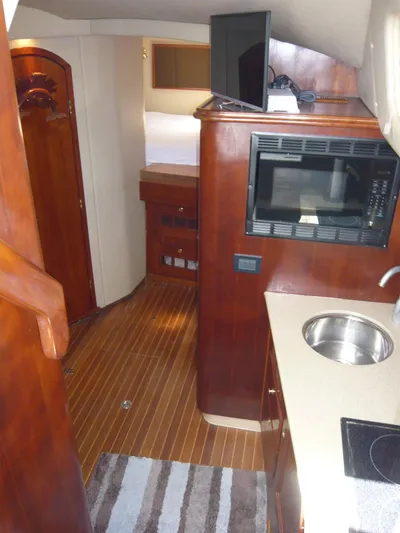 Bobalu Yacht Photos Pics 2004 Rampage 38 Express interior with kitchenette, microwave, sink, and wood flooring.